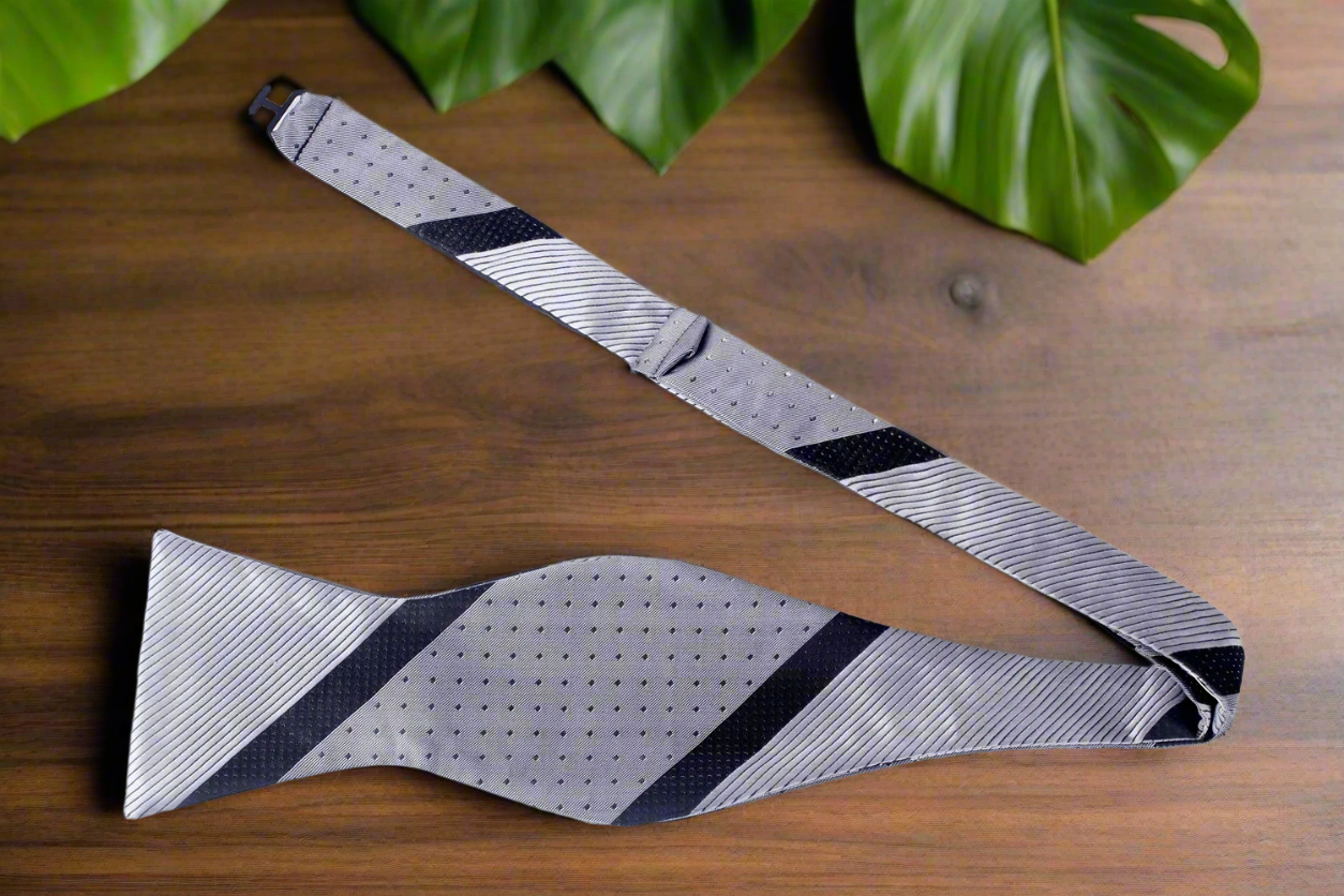 Top-down view of self tie bow tie in burgundy with bold center stripe, perfect for formal wedding settings.