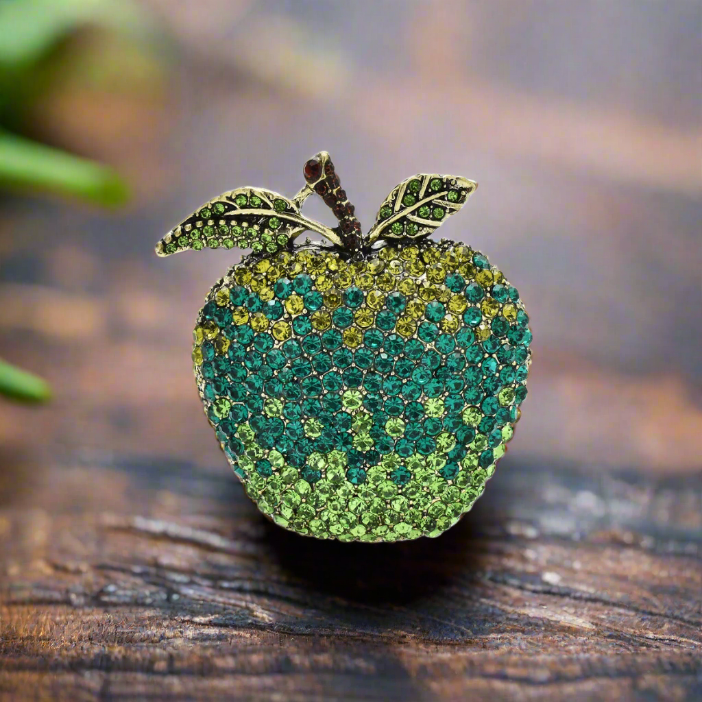Charming multicolor gemstone apple pin displayed against a white blouse background.