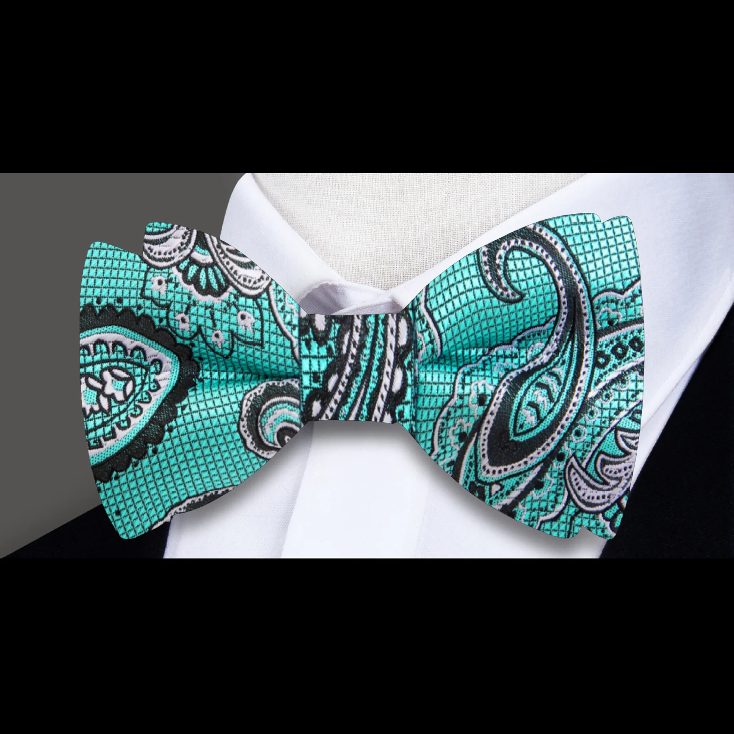 Groom wearing self tie paisley bow tie at garden wedding, paired with navy suit