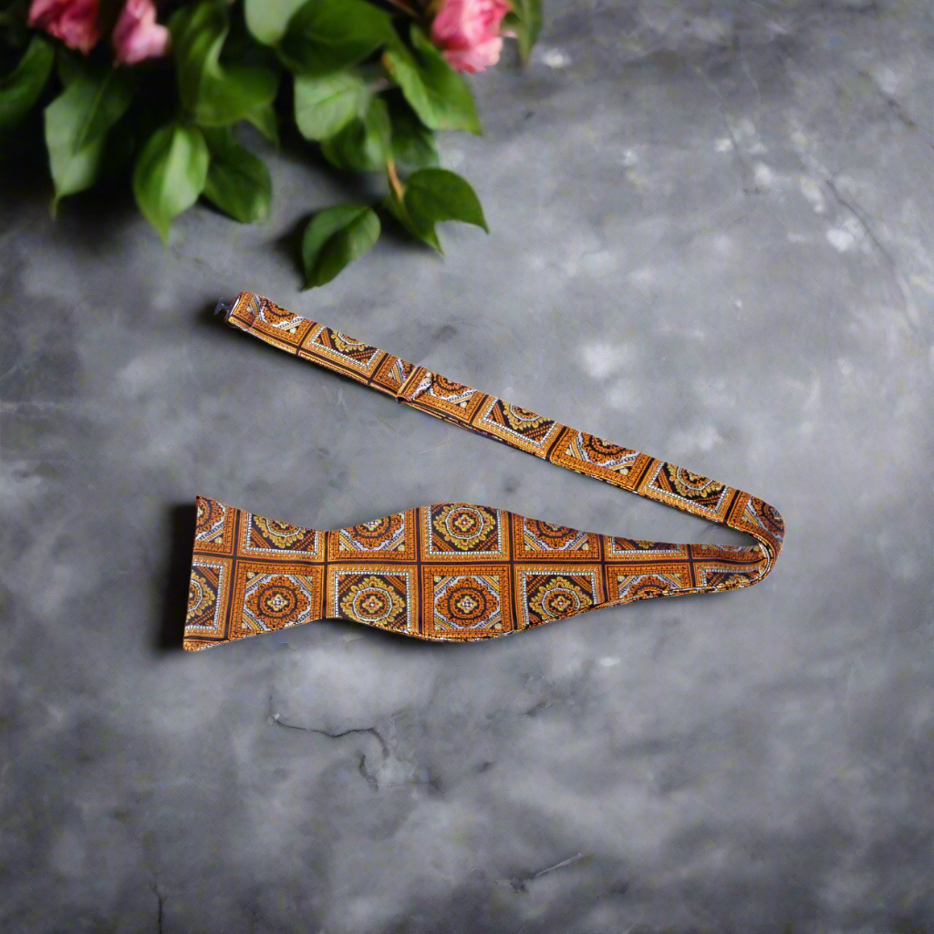 Front view of the geometric self-tie bow tie in orangish brown tones, highlighting its modern pattern and elegant design.