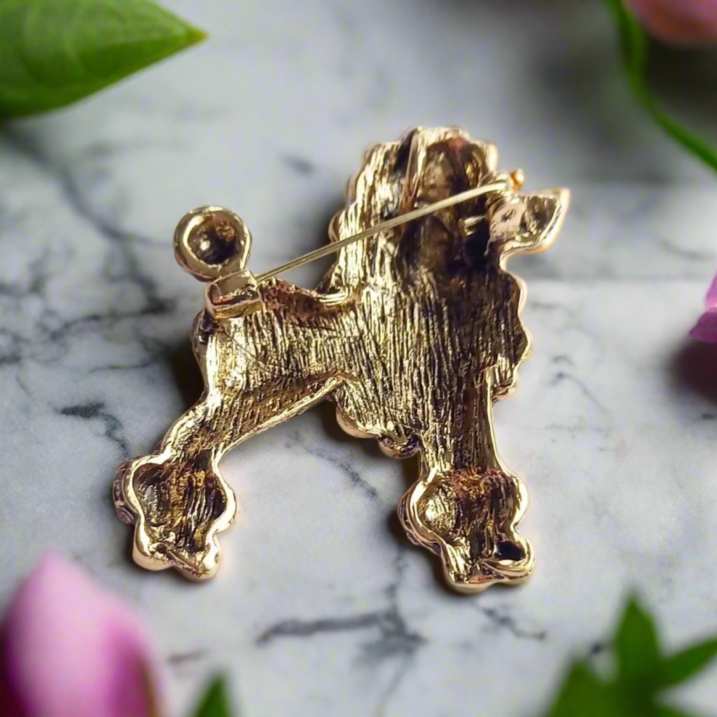 Orange poodle lapel pin displayed on a light blue blazer, highlighting its vibrant color.