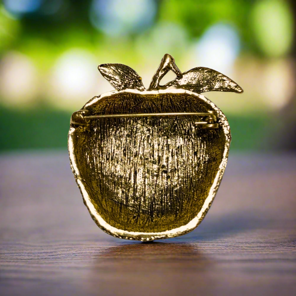 Charming multicolor gemstone apple pin displayed against a white blouse background.