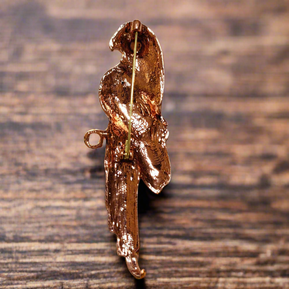 The parrot lapel pin worn on a blazer collar at a summer wedding.