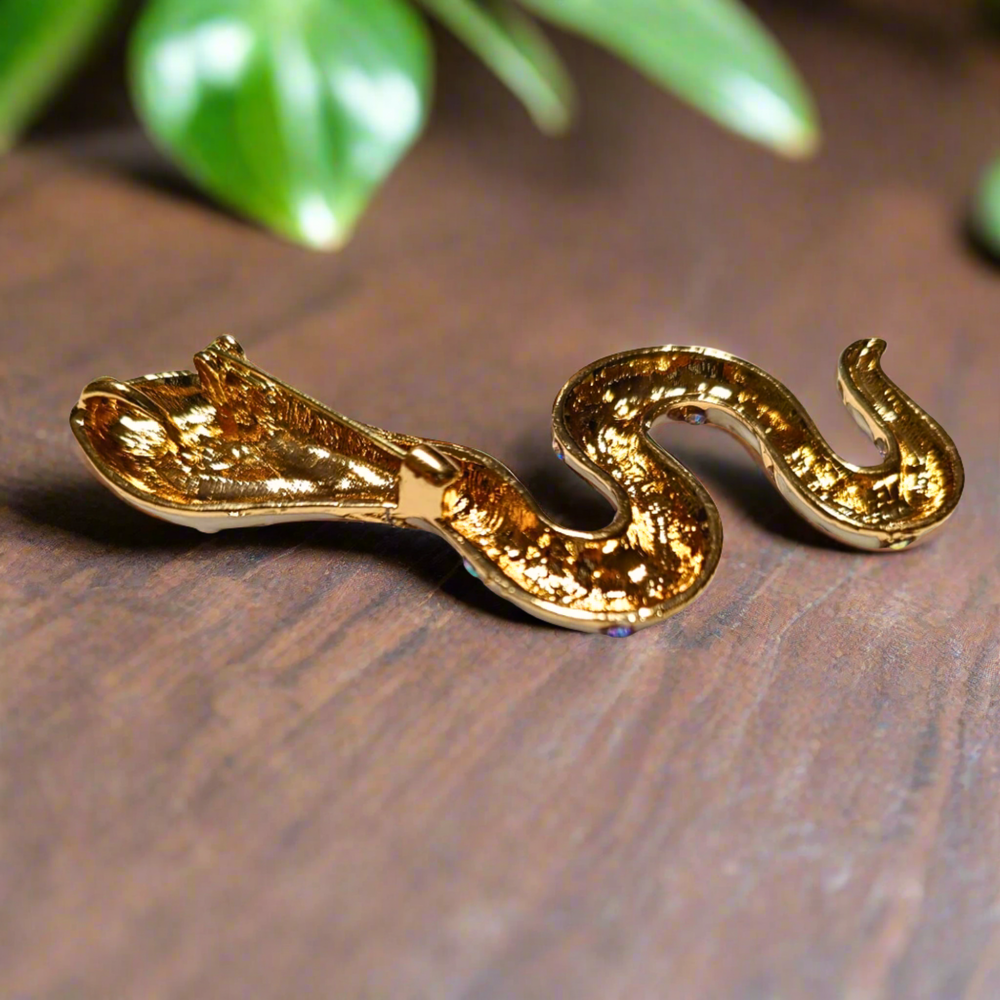The unique serpent lapel pin displayed elegantly against a dark background, highlighting its beauty.