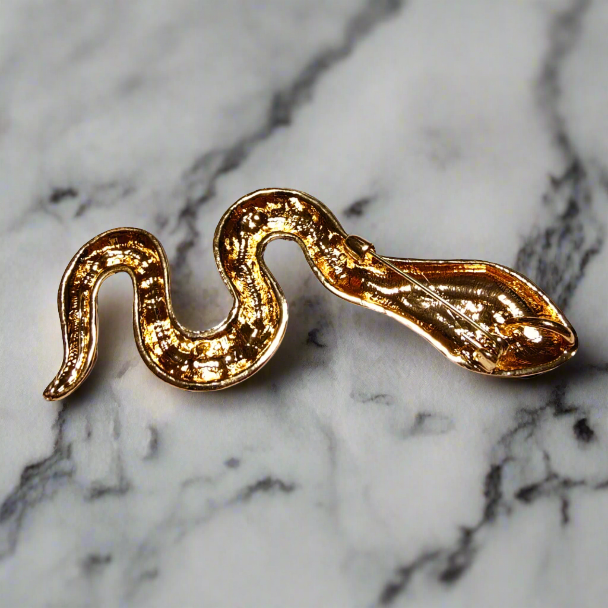 Styled image of the snake brooch on a tailored suit jacket, perfect for formal events.