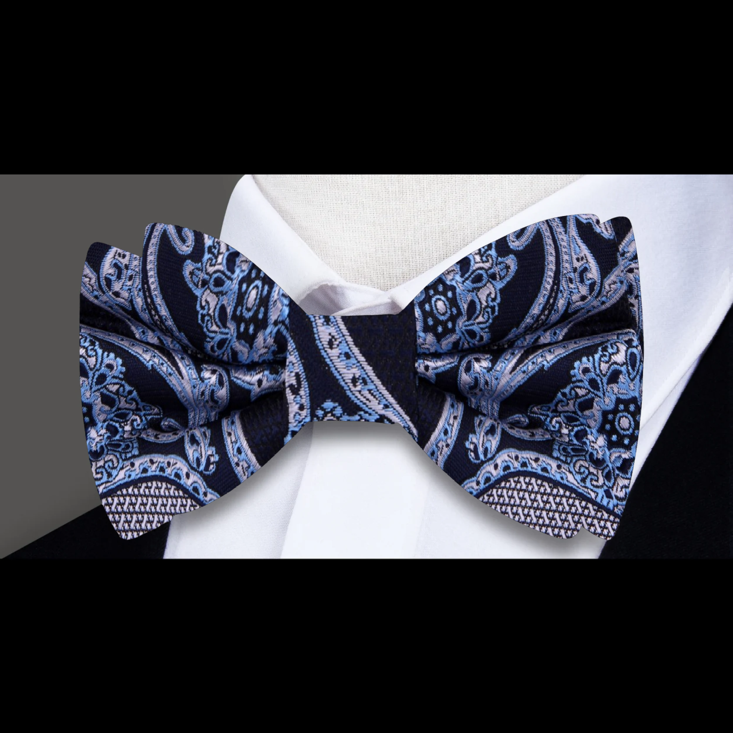 Self-tie red paisley bow tie displayed against a crisp white shirt, ideal for weddings and galas.