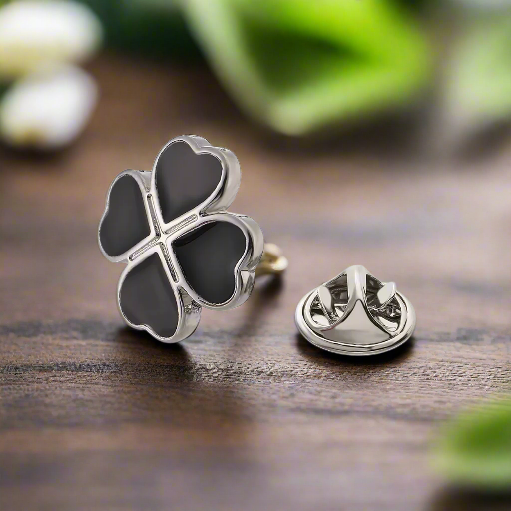 Black and chrome four leaf clover lapel pin on a white dress shirt
