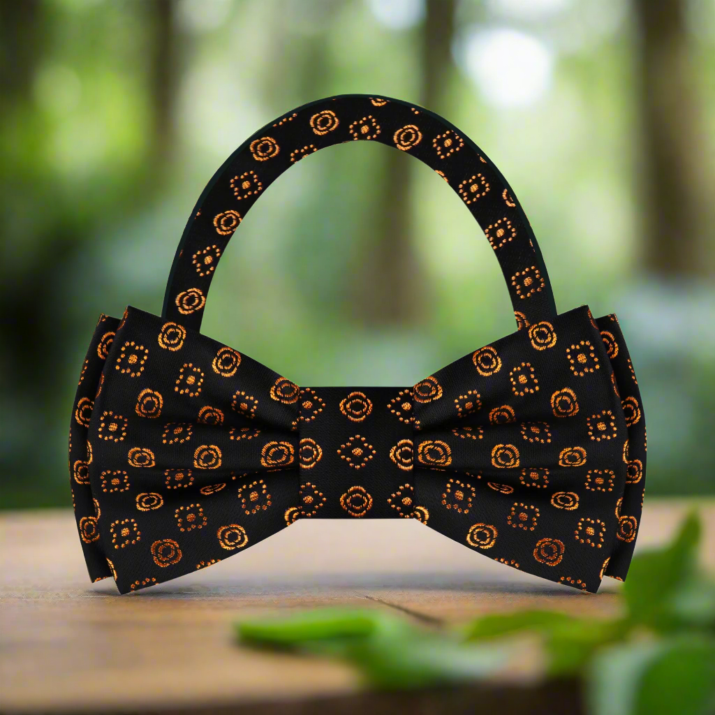 Elegant black silk bow tie with gold geometric accents on a white background.