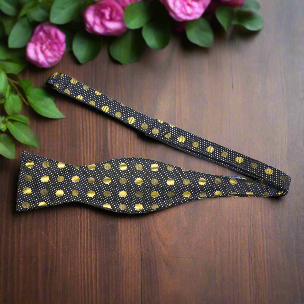 Model wearing the gold polka dot bow tie at a wedding, demonstrating its versatile style.