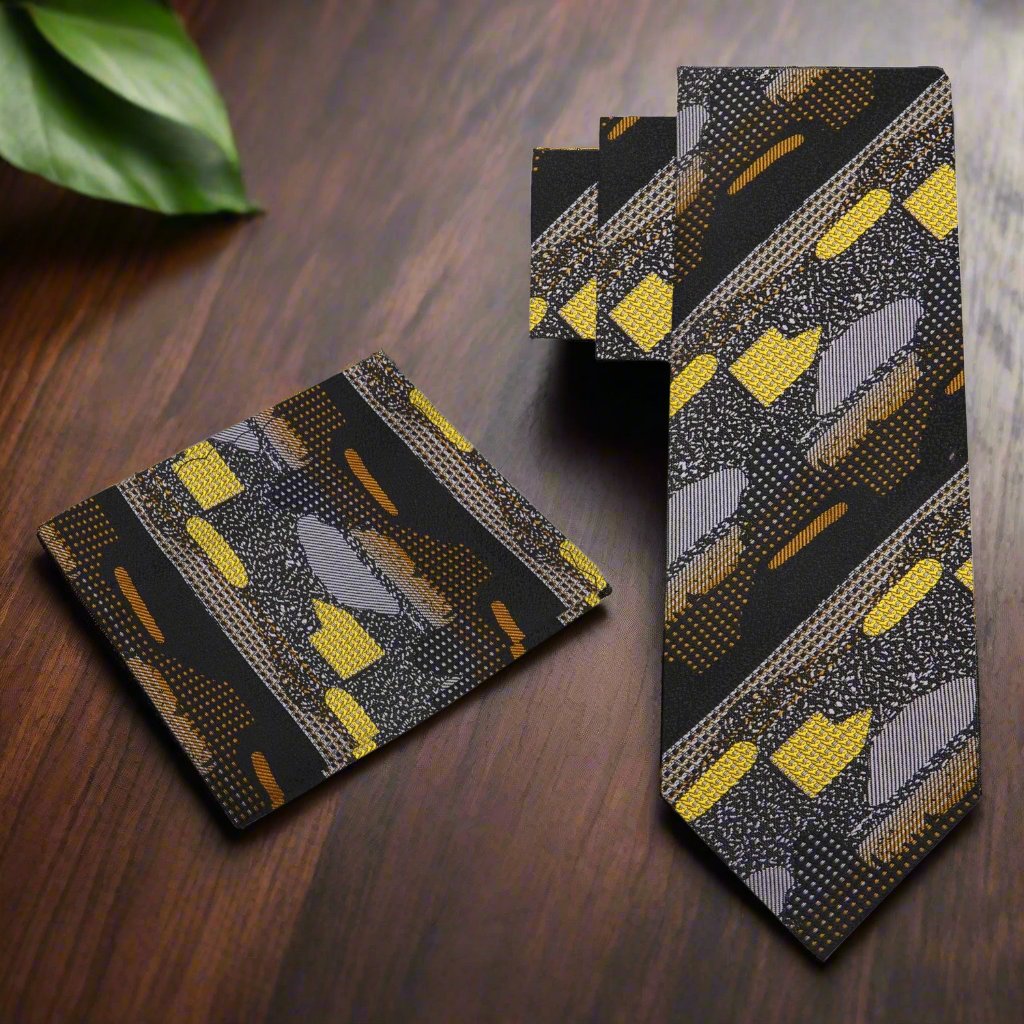 Close-up of the black and gold necktie, highlighting the intricate details of its abstract pattern and silk material.