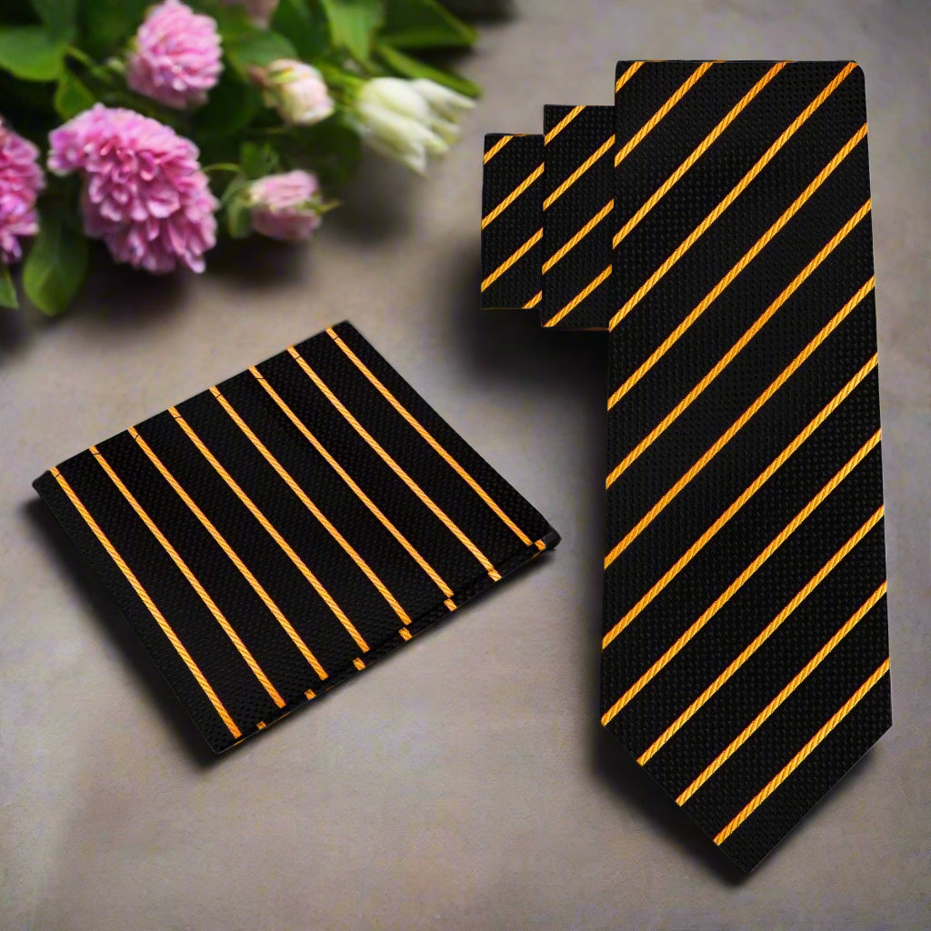 Close-up of black silk tie with gold stripes laying on a charcoal suit