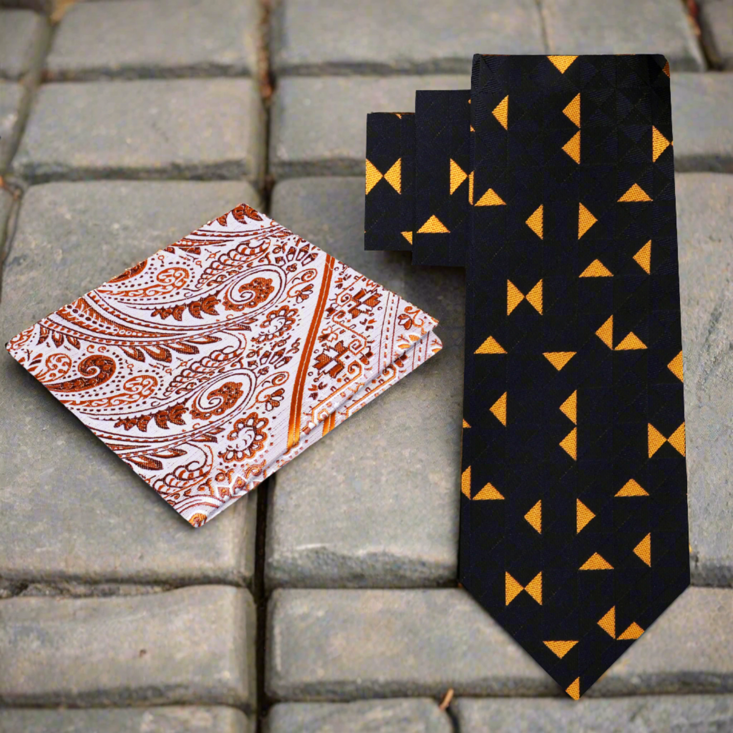 Close-up of black silk tie with bold orange triangle pattern for formal attire