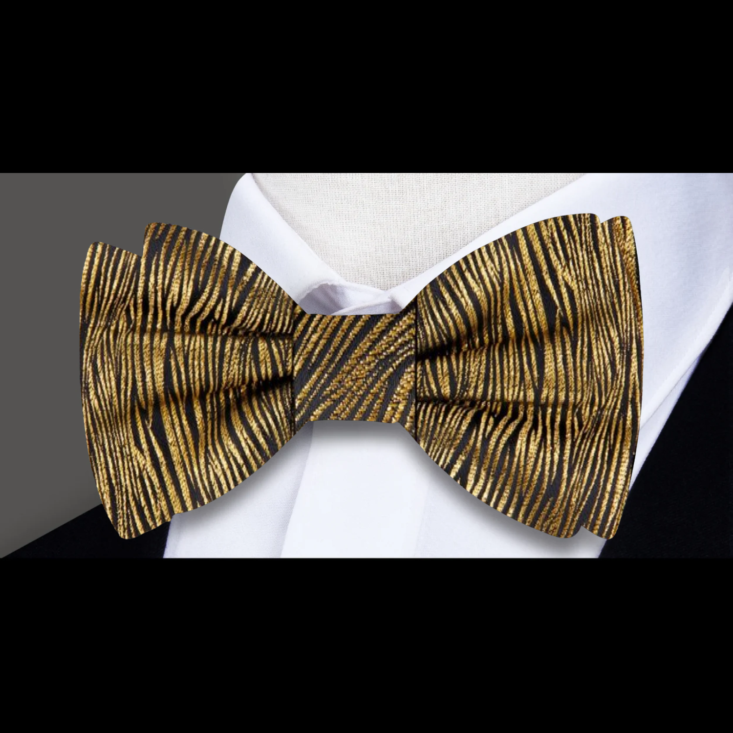 Close-up of the metallic gold zebra pattern on a stylish silk bow tie