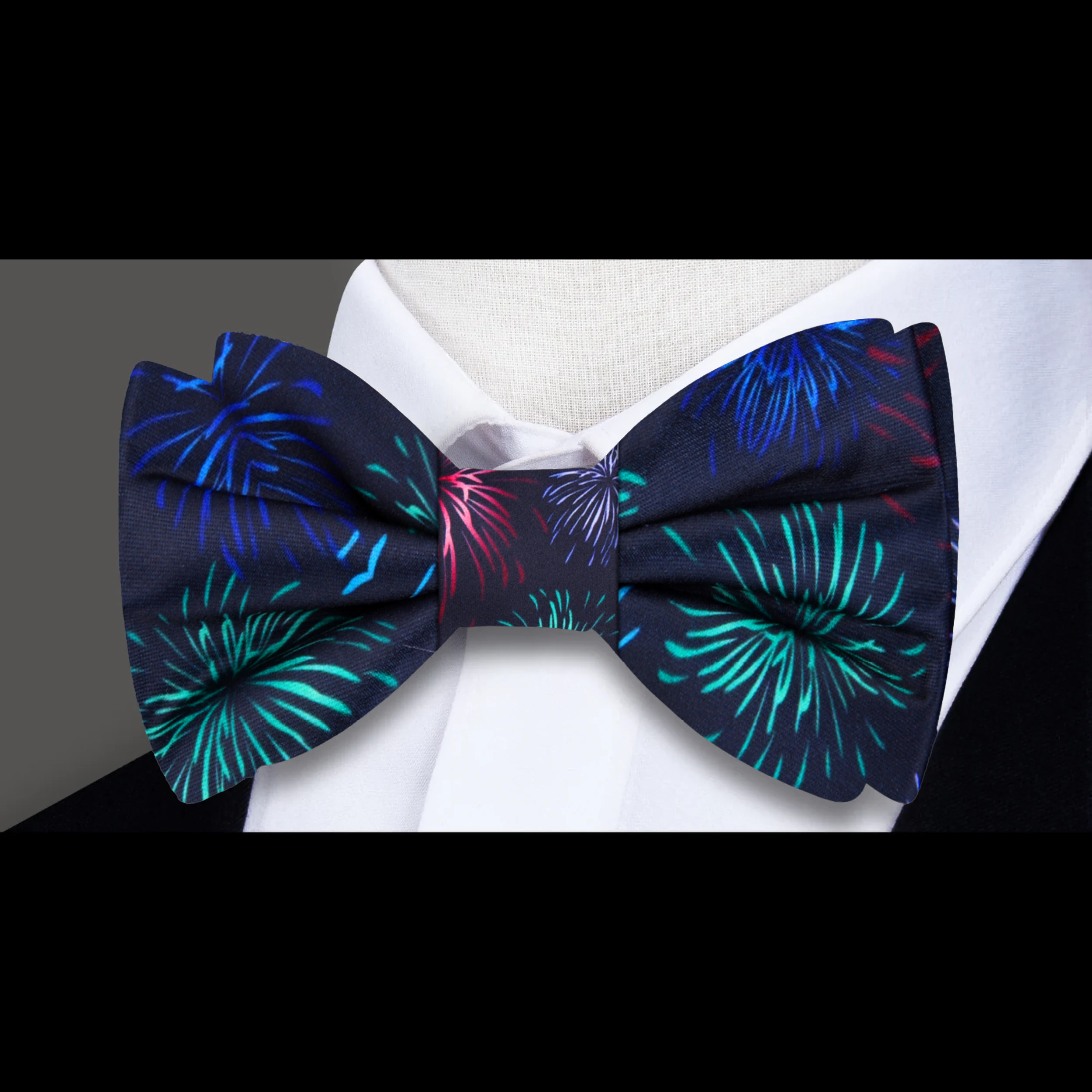 Model wearing the fireworks silk bow tie paired with a classic black suit for a formal event.
