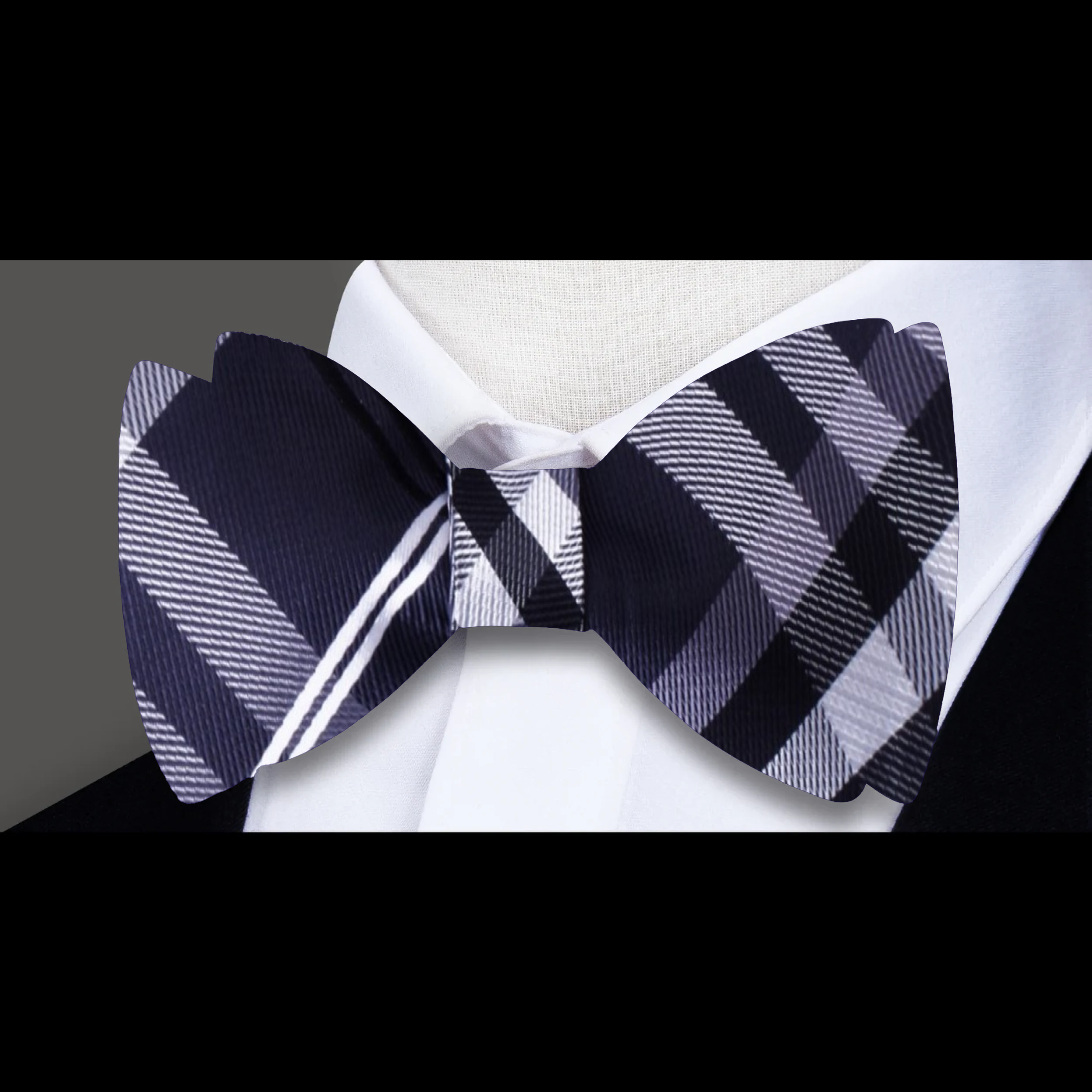 Men tying a plaid bow tie in a modern office setting