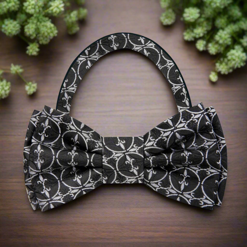 Model wearing the brown geometric bow tie with a charcoal grey suit at a formal event.