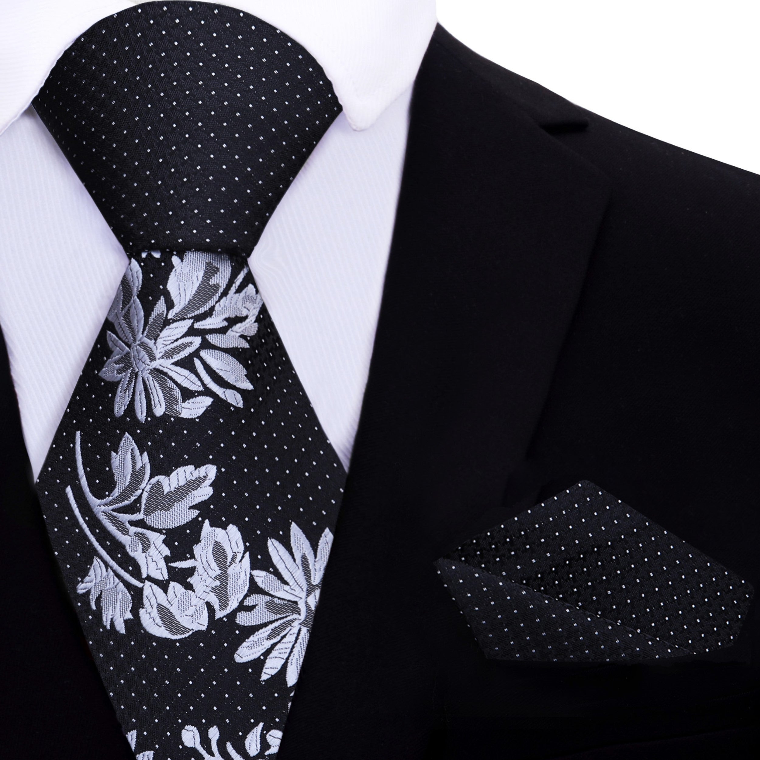 Close-up of a stylish black silk tie with floral pattern at the bottom