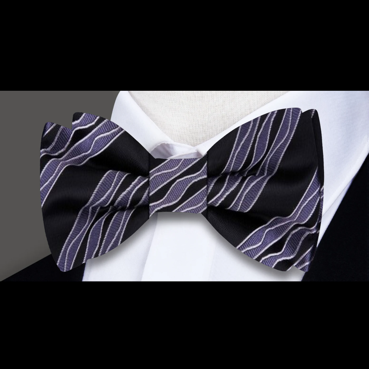 Man wearing a grey silk bow tie with a modern, sophisticated look