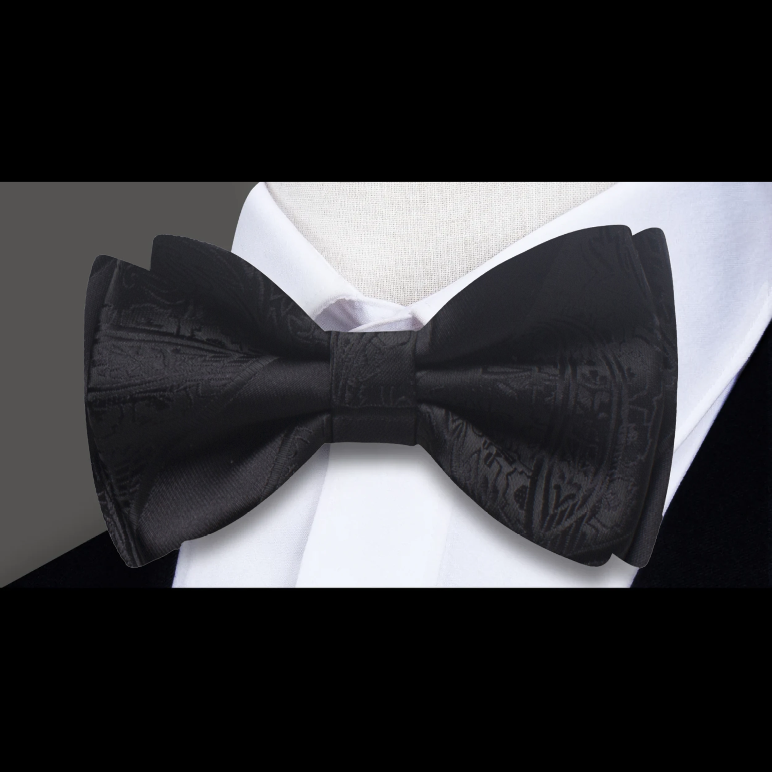 Close-up of the luxurious bow tie showcasing intricate details in paisley and stripes.