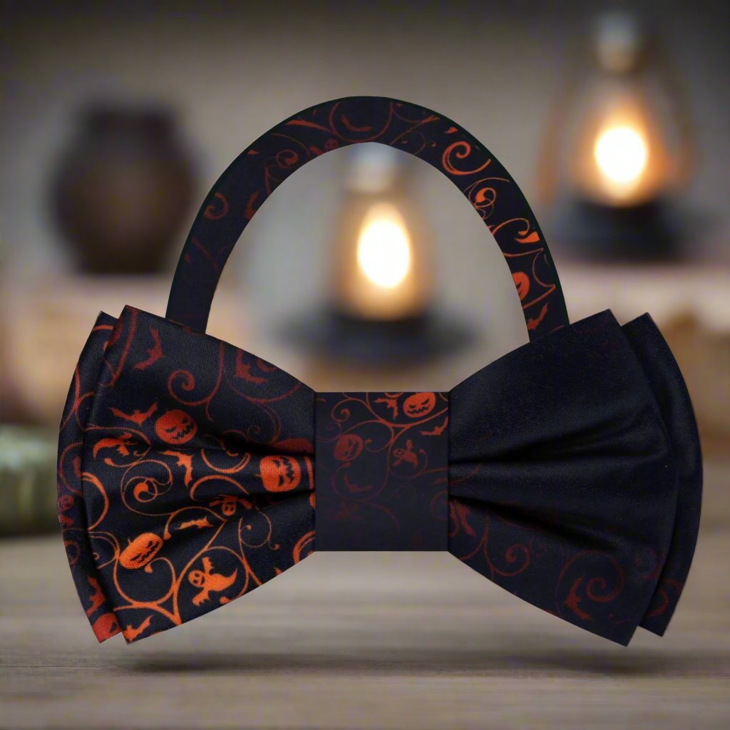 Close-up view of the black and orange silk Halloween bow tie showcasing intricate patterns of pumpkins and bats.