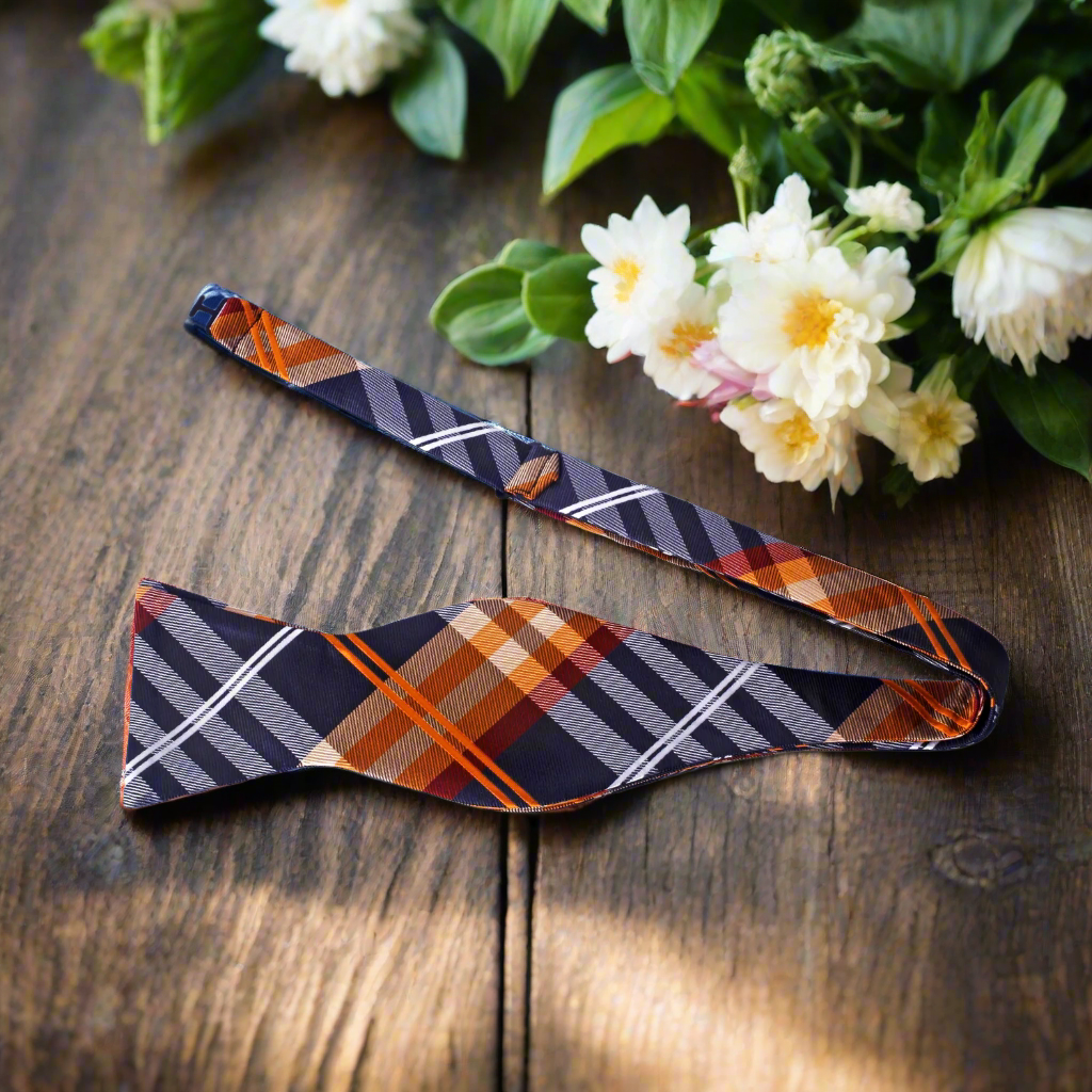 Close-up of a black and green plaid bow tie on a model