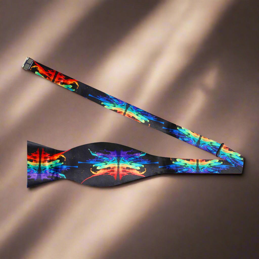 Close-up of black silk bow tie with vibrant paint splash pattern, ideal for formal wear