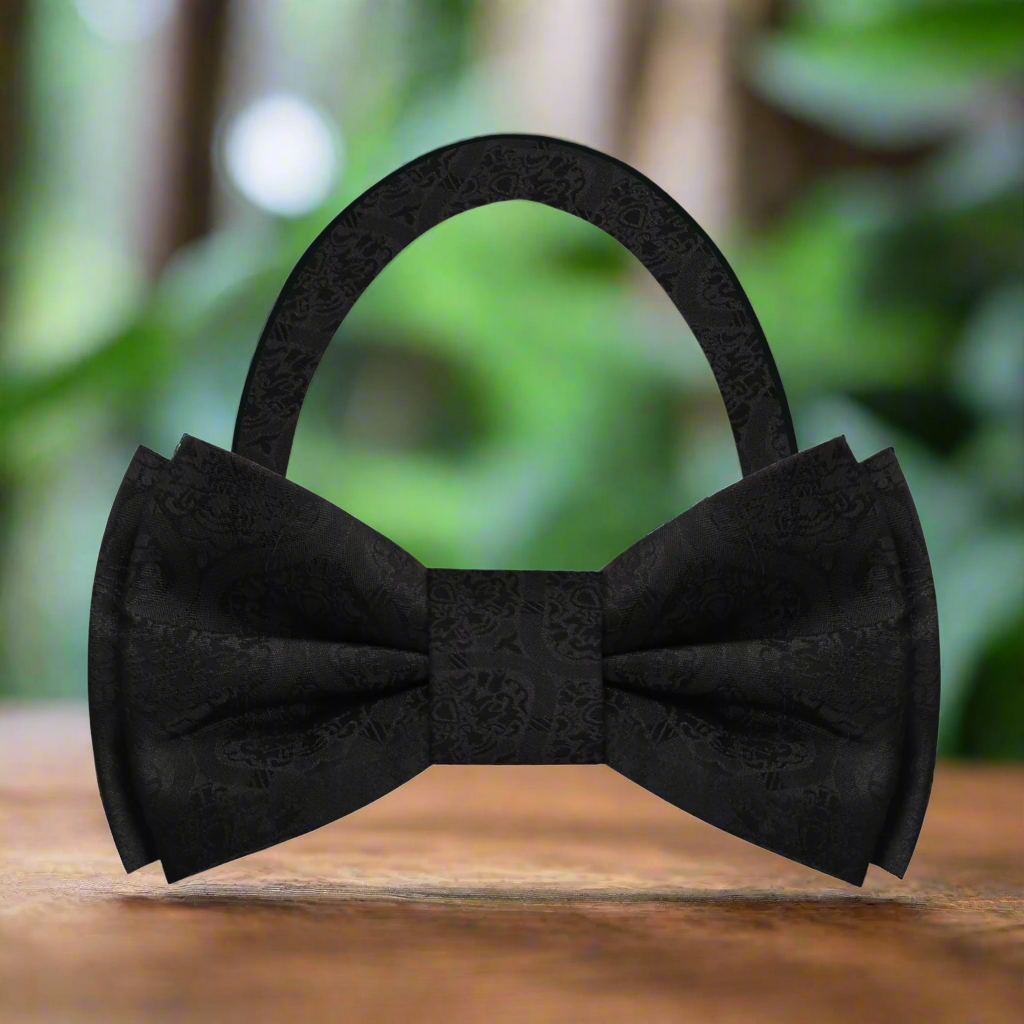 Close-up of the expressive abstract silk bow tie showcasing its vibrant brown and blue pattern.