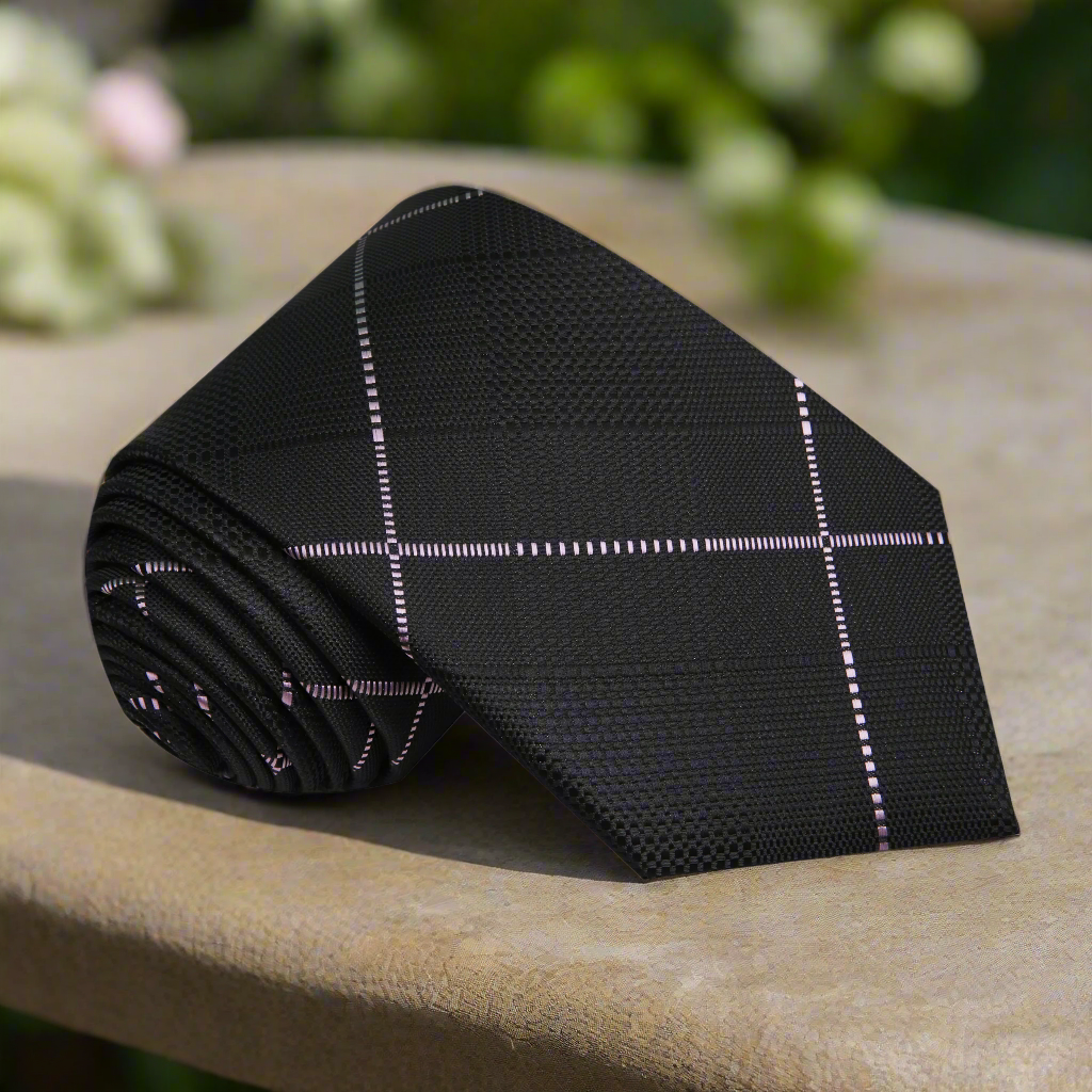 Front view of the stylish black plaid necktie showcasing the pink pattern.