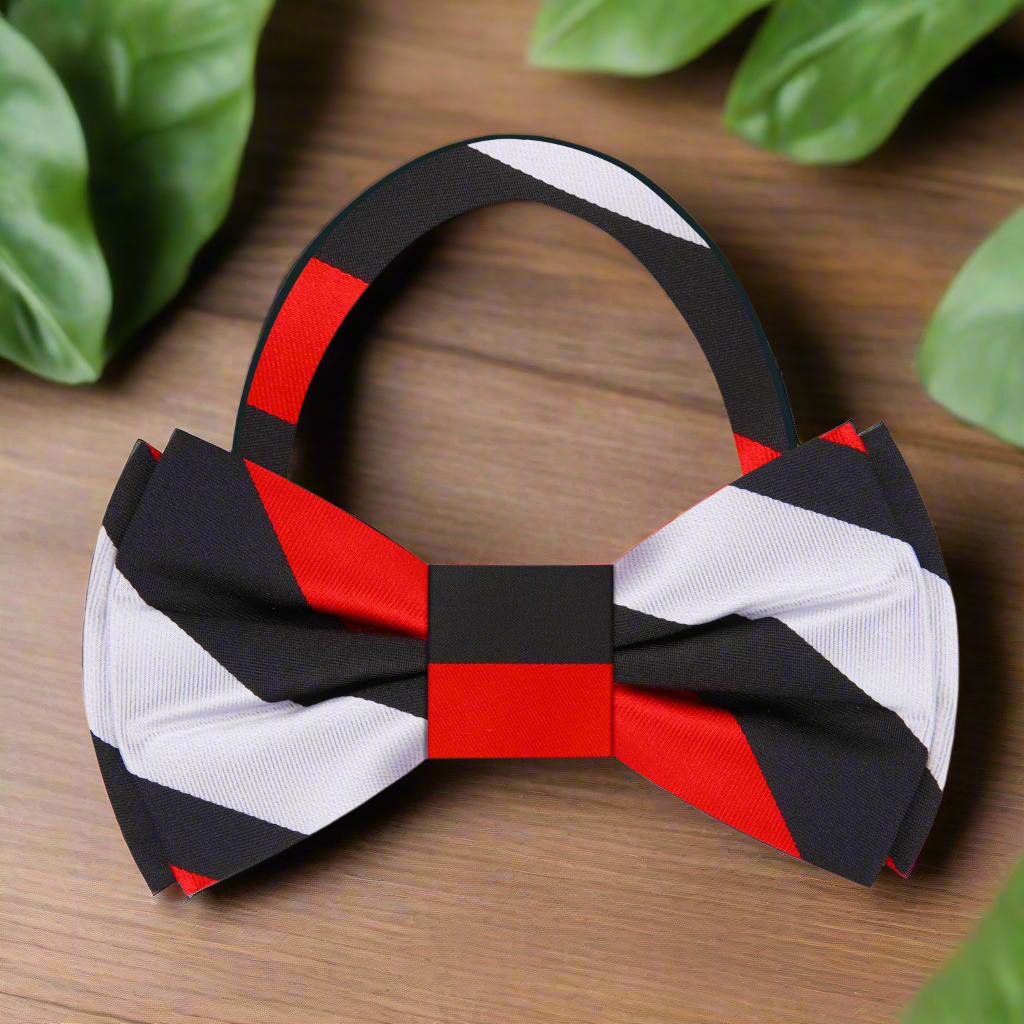 Man wearing a pre-tied stripe bow tie with a tailored suit at a wedding