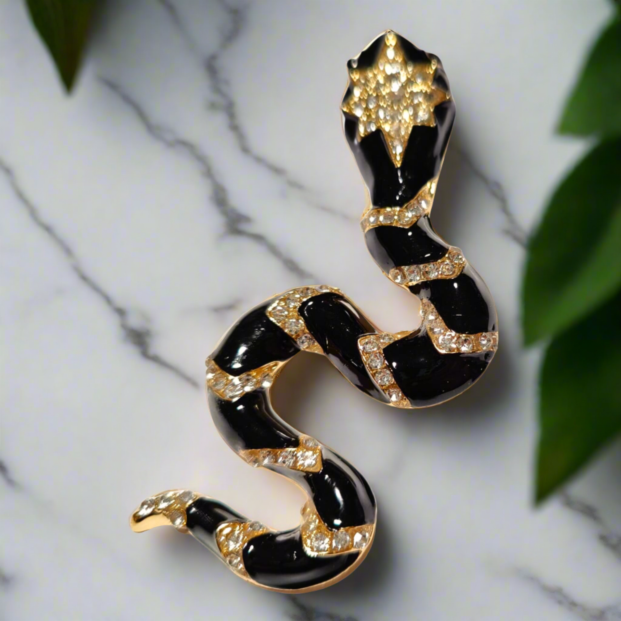 The unique serpent lapel pin displayed elegantly against a dark background, highlighting its beauty.