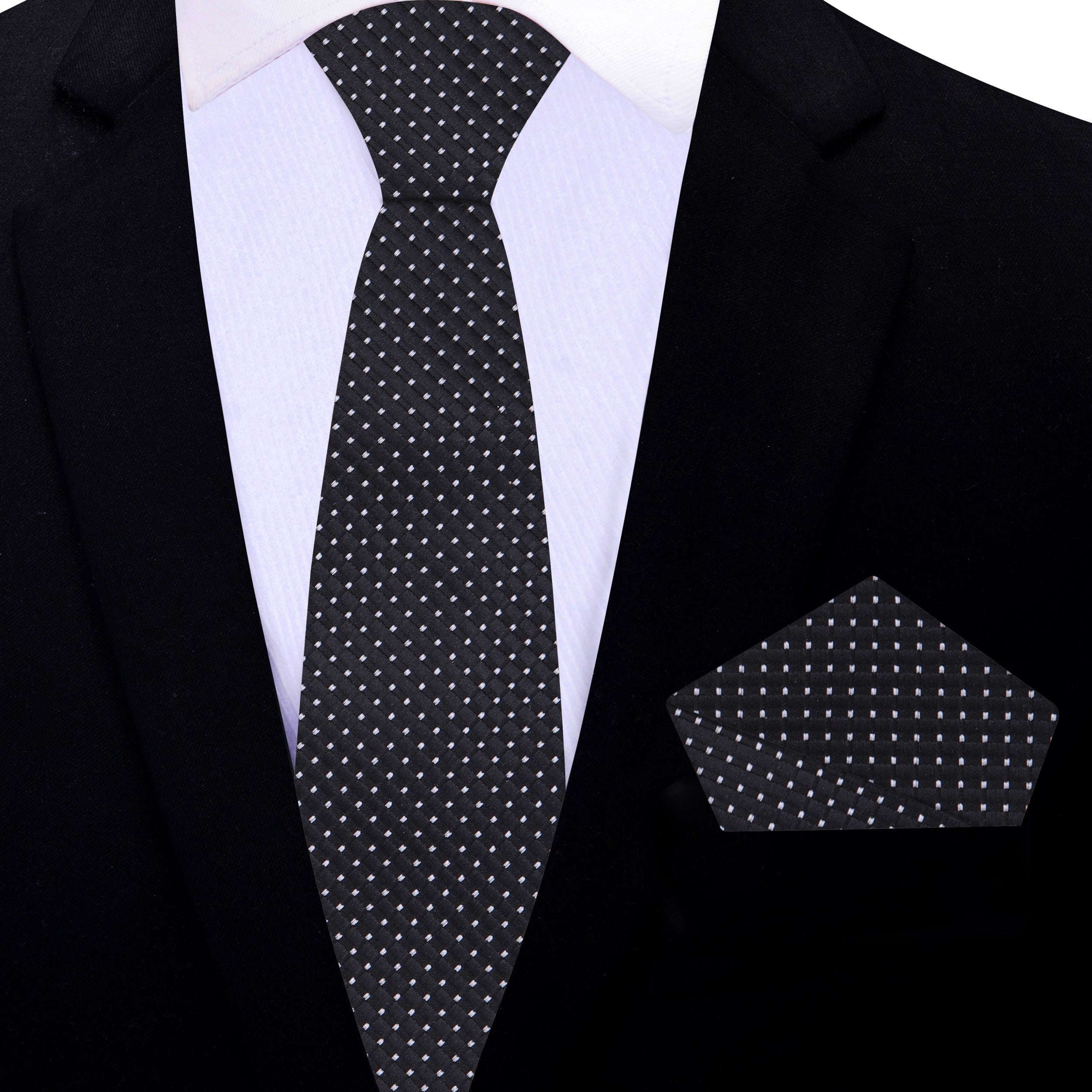Stylish black tie worn with a light grey dress shirt and charcoal suit, perfect for meetings.