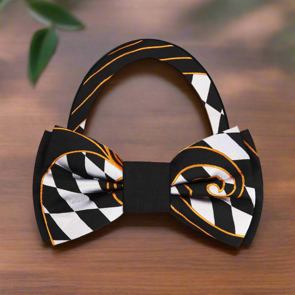 Close-up of luxurious checkered silk bow tie featuring gold paisley accents, ideal for formal occasions.