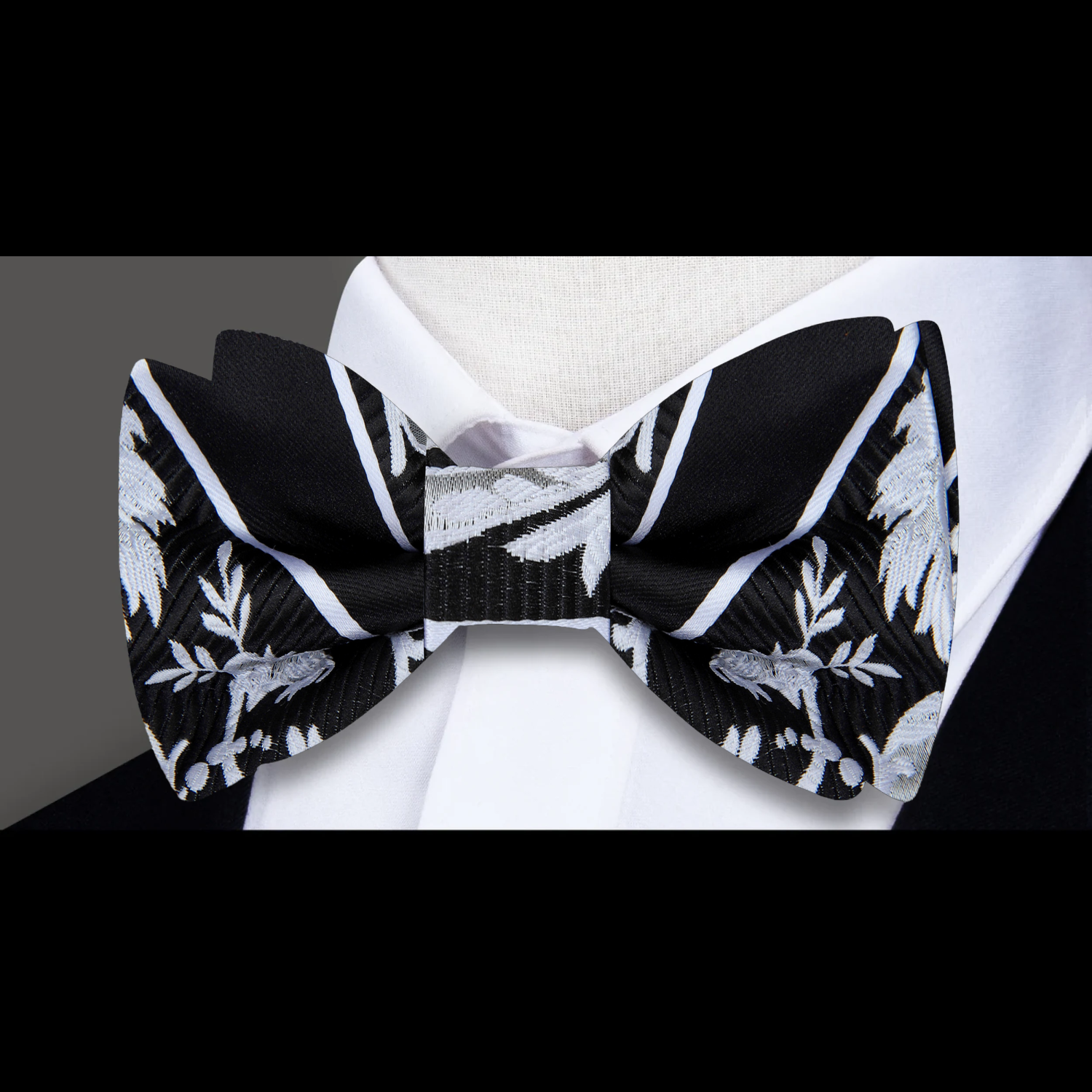 Close-up of black floral bow tie with red accents for formal wear