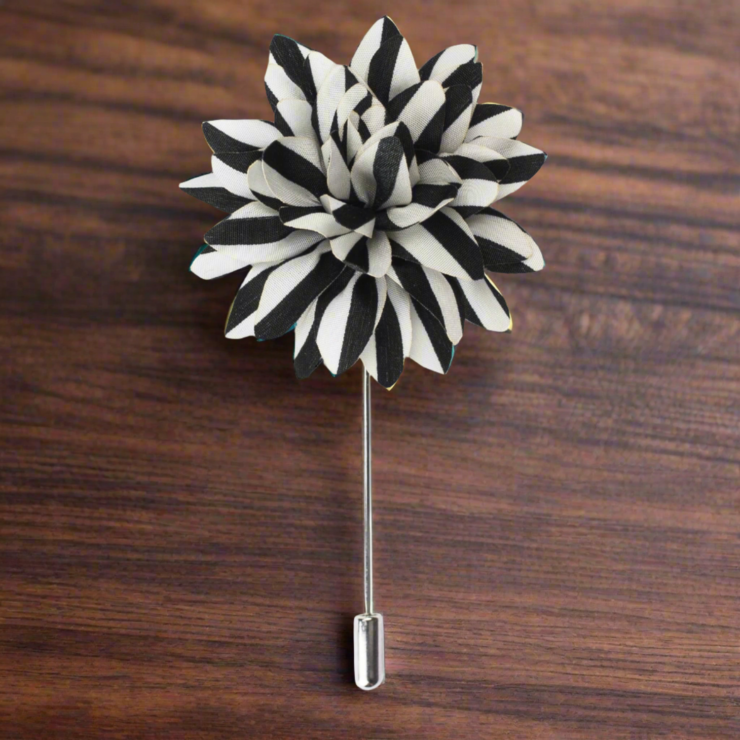 Close-up of a black and white striped lapel pin, showcasing its elegant design.