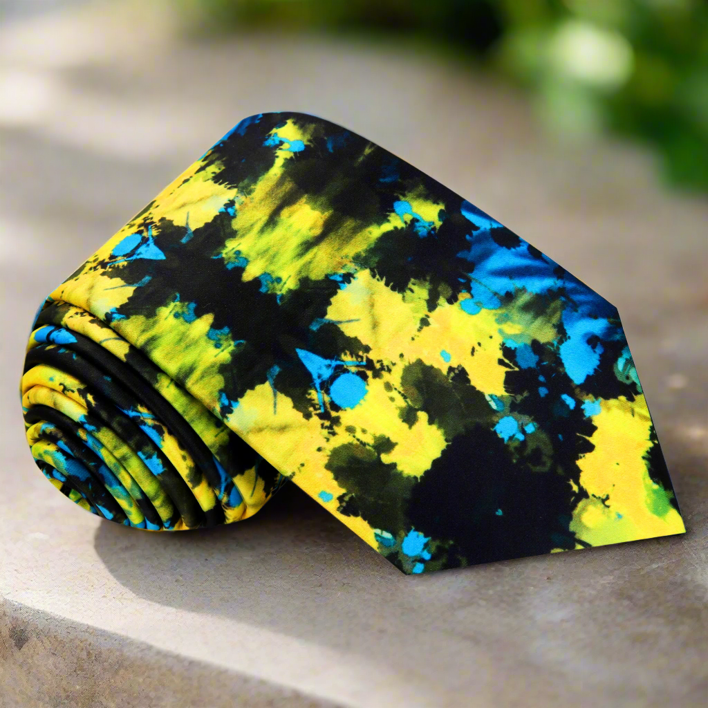 Front view of a stylish men's silk necktie with abstract inkblot pattern in black, green, and yellow