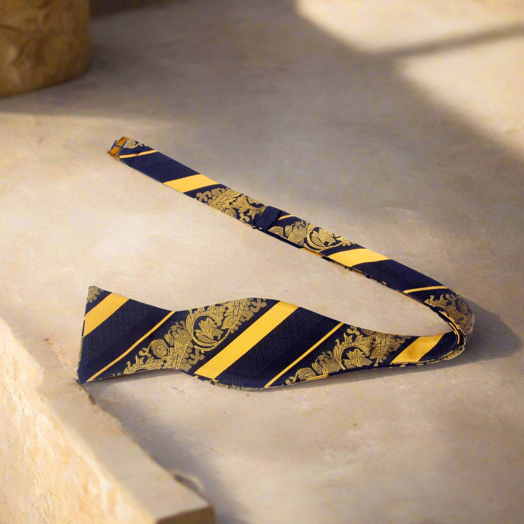 Man adjusting a silk floral bow tie with vibrant blue pattern
