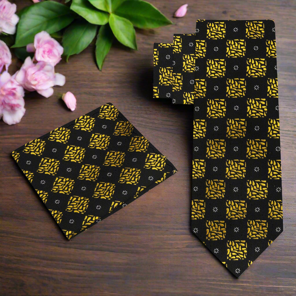 Close-up of black and gold geometric necktie showcasing bold pattern and luxurious silk fabric