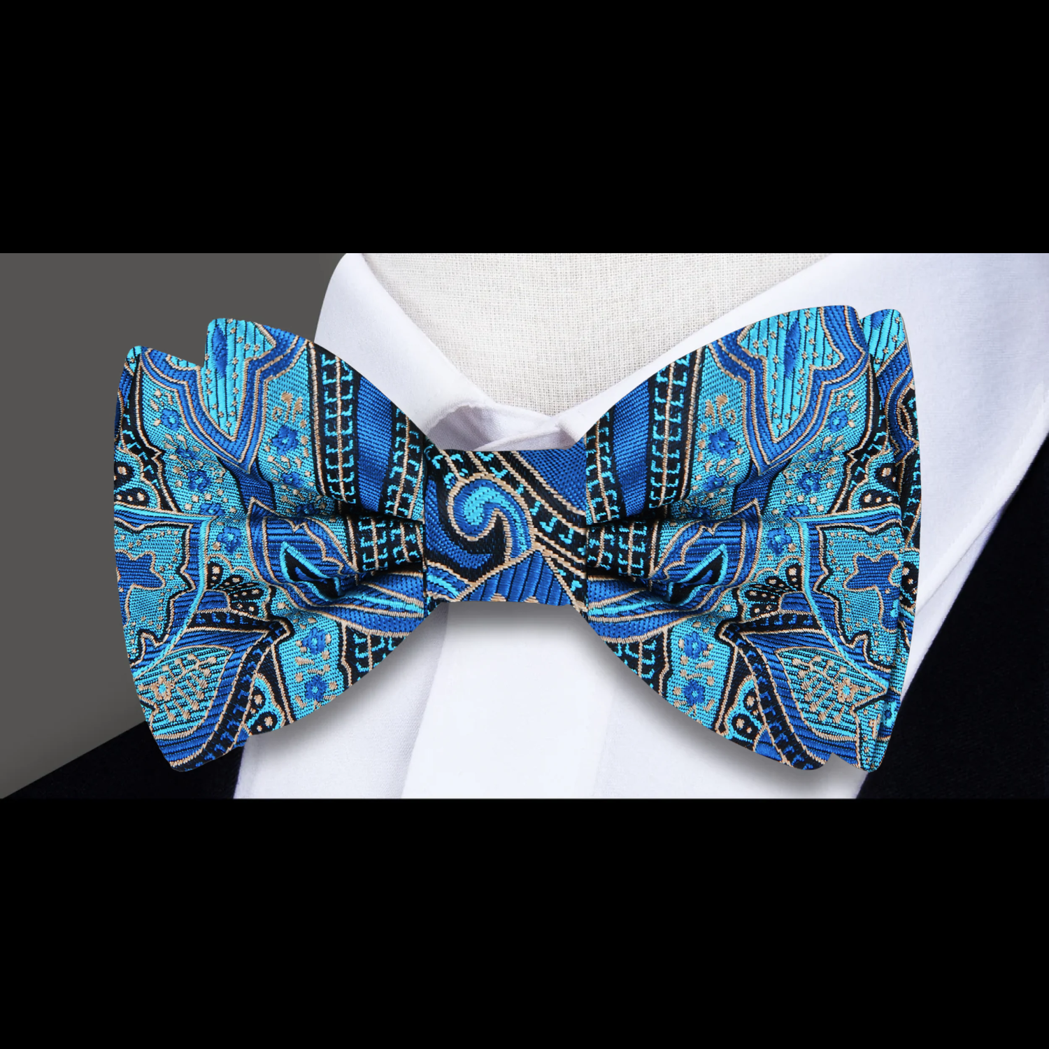 Close-up of the detailed paisley pattern on a teal bow tie, highlighting the rich color and silk material.