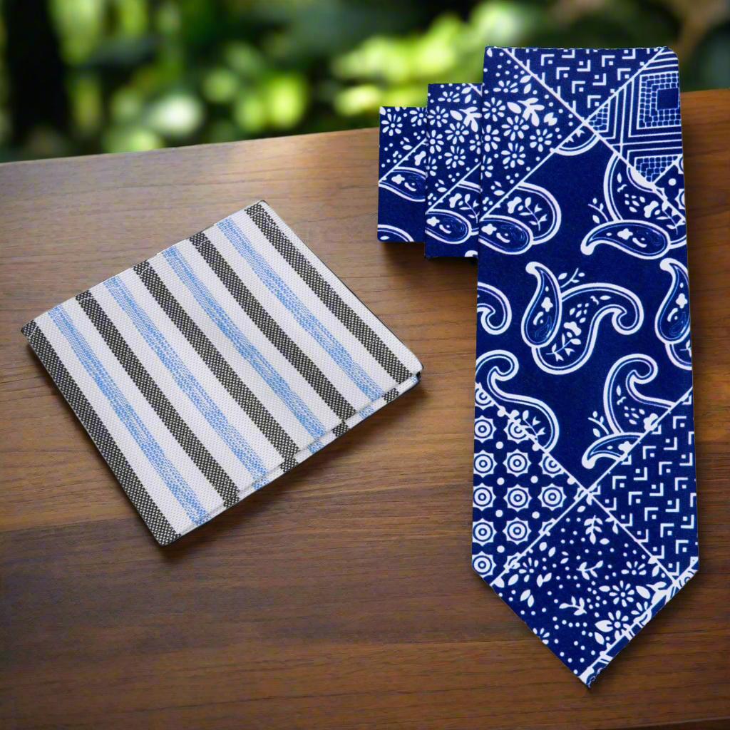 Close-up of navy paisley necktie draped over a light gray dress shirt, highlighting the contrast.