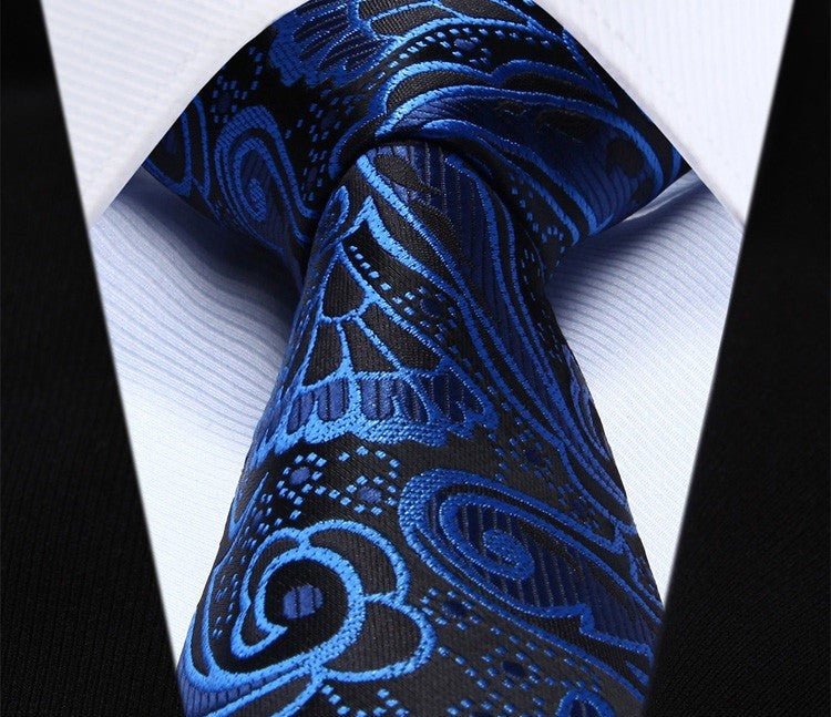 Close-up of burgundy paisley silk necktie highlighting its luxurious fabric and detailed design.