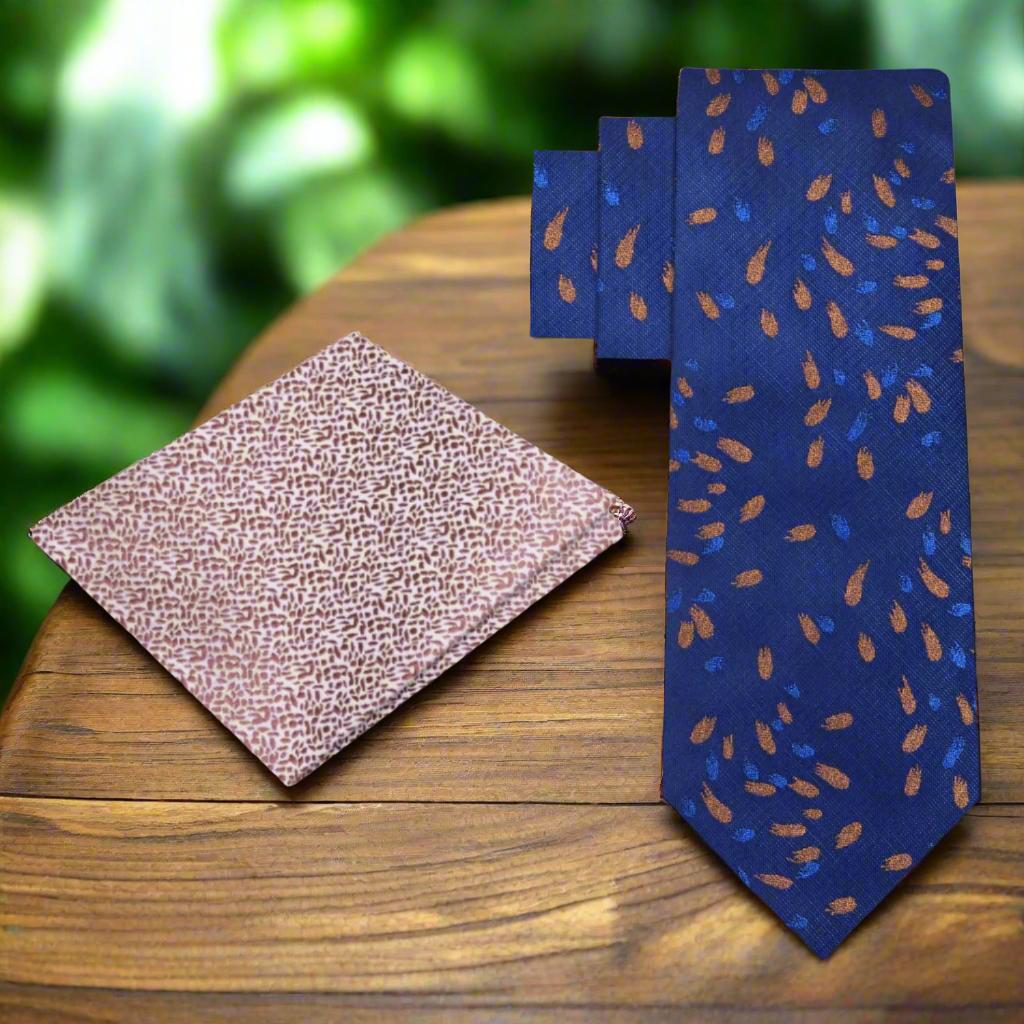 Dark blue silk tie with comet pattern displayed on a dress shirt.