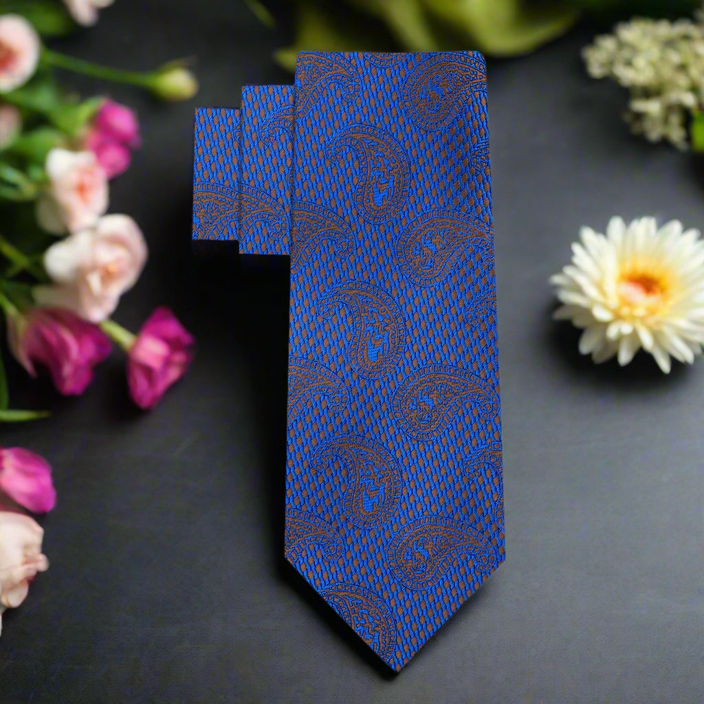 Close-up of the paisley pattern on the dark blue silk tie, highlighting the intricate design and luxurious texture.