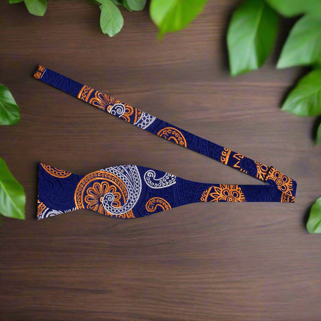 Man adjusting a self-tie paisley bow tie with vibrant pattern