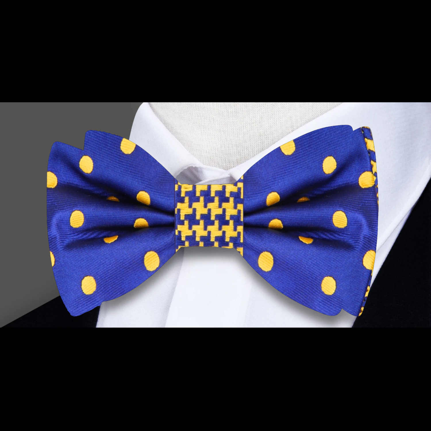 Model wearing dark blue and gold bow tie for wedding with navy suit