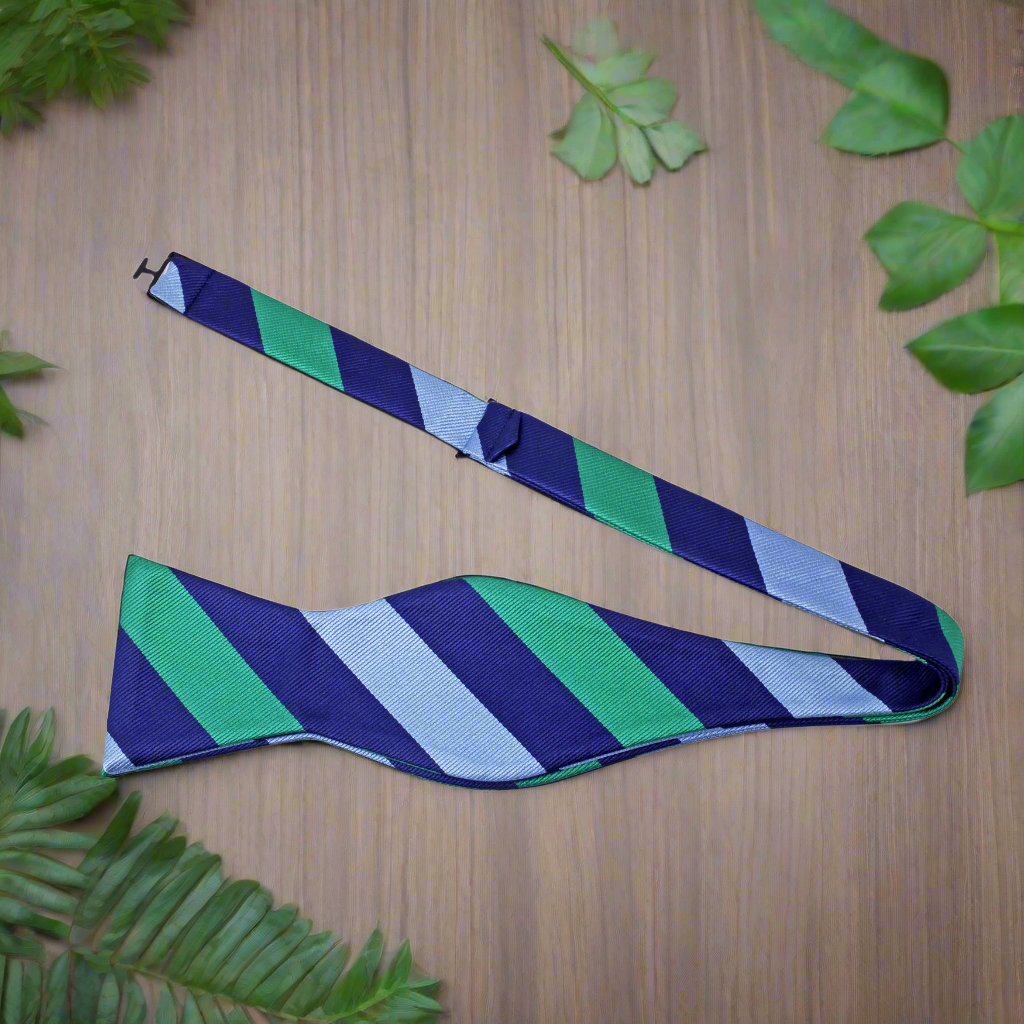 Man wearing a self-tie striped bow tie with a charcoal suit at a formal event