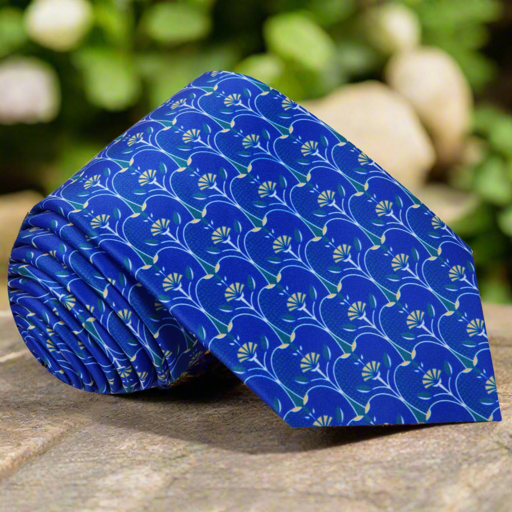 Close-up of a blue silk necktie featuring an apple slice pattern, perfect for casual office wear.