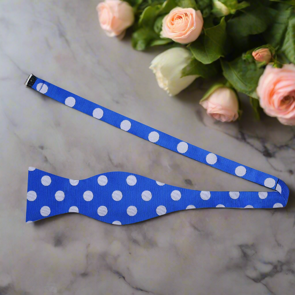 Polka dot bow tie worn with a navy suit, perfect for weddings and formal events.