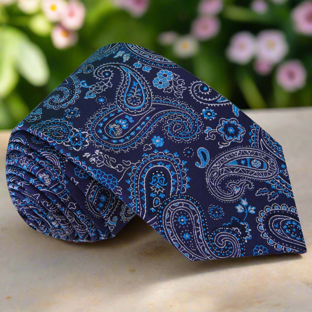 Elegant blue paisley silk necktie draped over a white shirt for formal wear