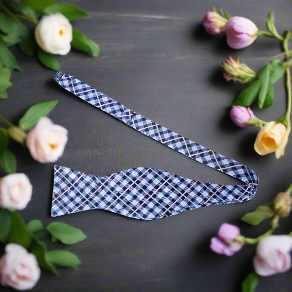Flat lay of the self tie bow tie and matching pocket square on a light grey suit
