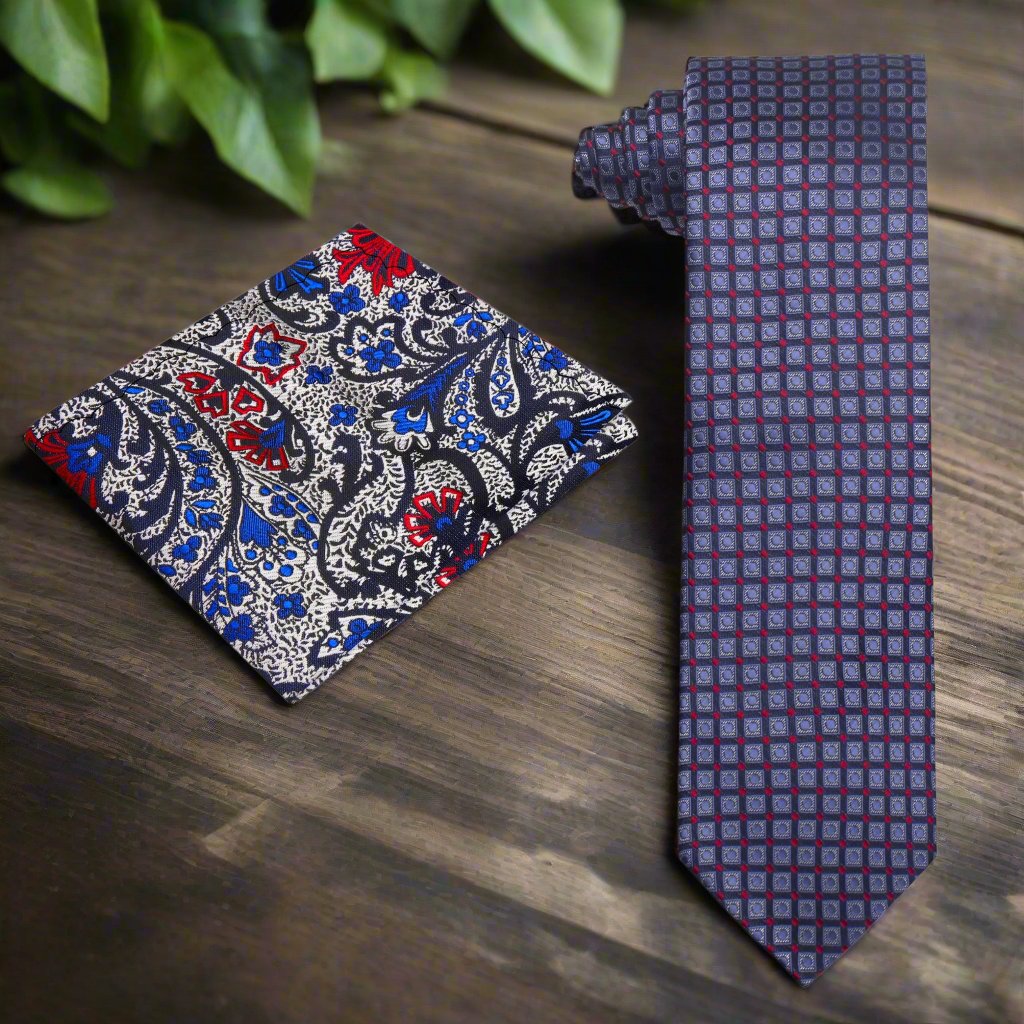 Silk geometric check necktie in blue and red laid out on a desk